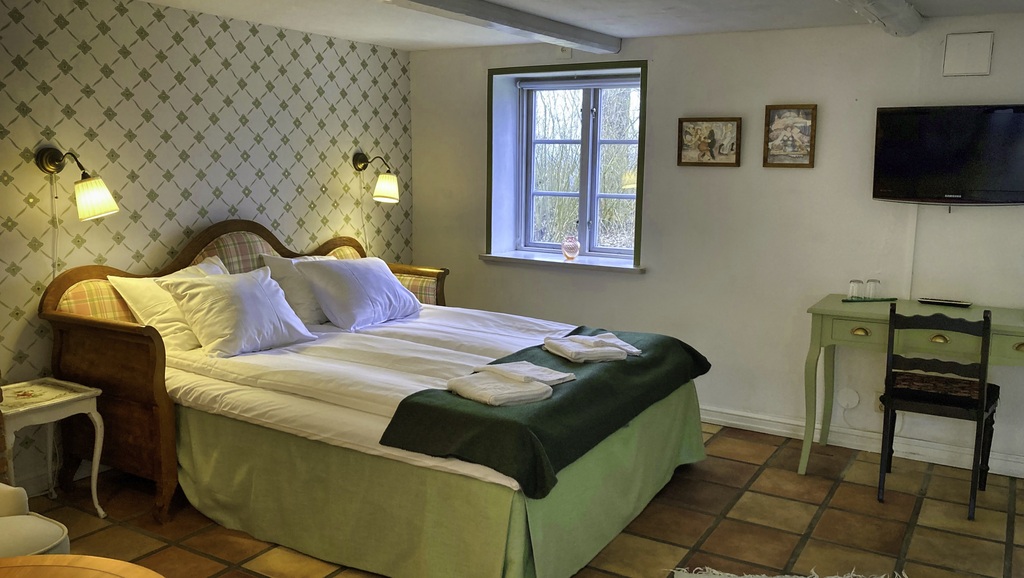 Bäddad dubbelsäng med fönsteri bakgrunden